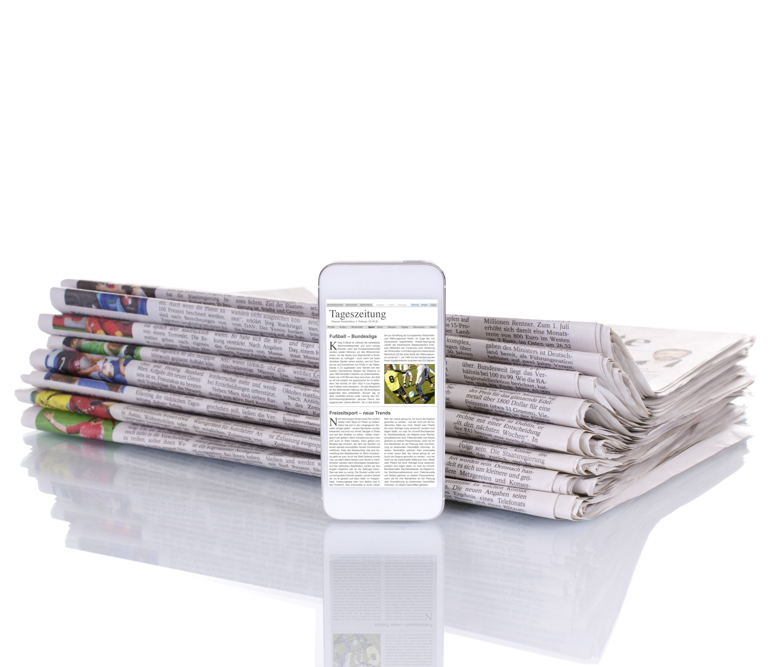 ein Stapel von Zeitschriften, davor ein Handy worauf ein Presseartikel zu sehen