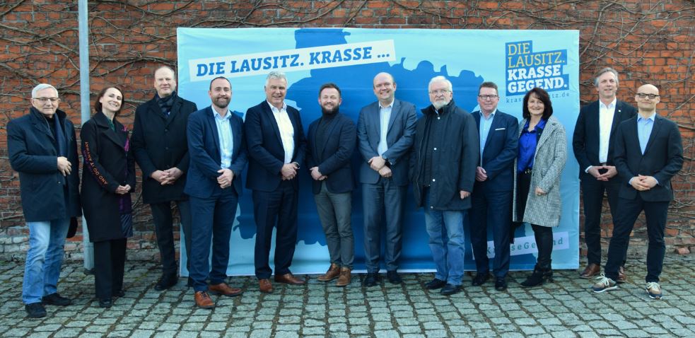 Die polnische Delegation aus Konin mit Vertretern der Staatskanzlei Brandenburg vor der Fotowand Krasse Lausitz