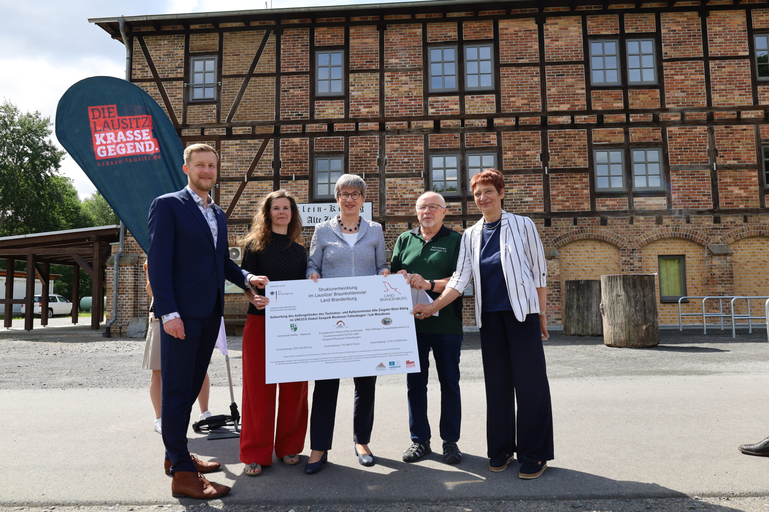 Zuwendungsbescheidübregabe vor der Zieglei Klein Kölzig mit SPN-Landrat Hr. Heusler, Geschäftsstellenleiterin Geopark Muskauer Faltenbogen Fr. Sauer, Ministerin Frau Schneider, Amtsdirektorin von Döbern Land Frau Manuela Mahnke und ein Mitarbeiter von der Ziegeleibahn